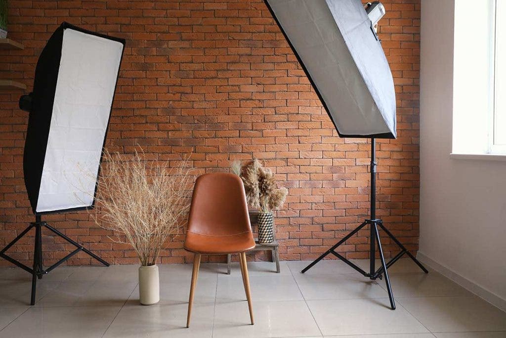 simple studio setup with chairs and softbox lights and brick wall background