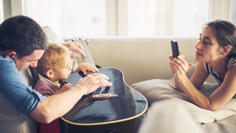 mother taking a picture of child with father