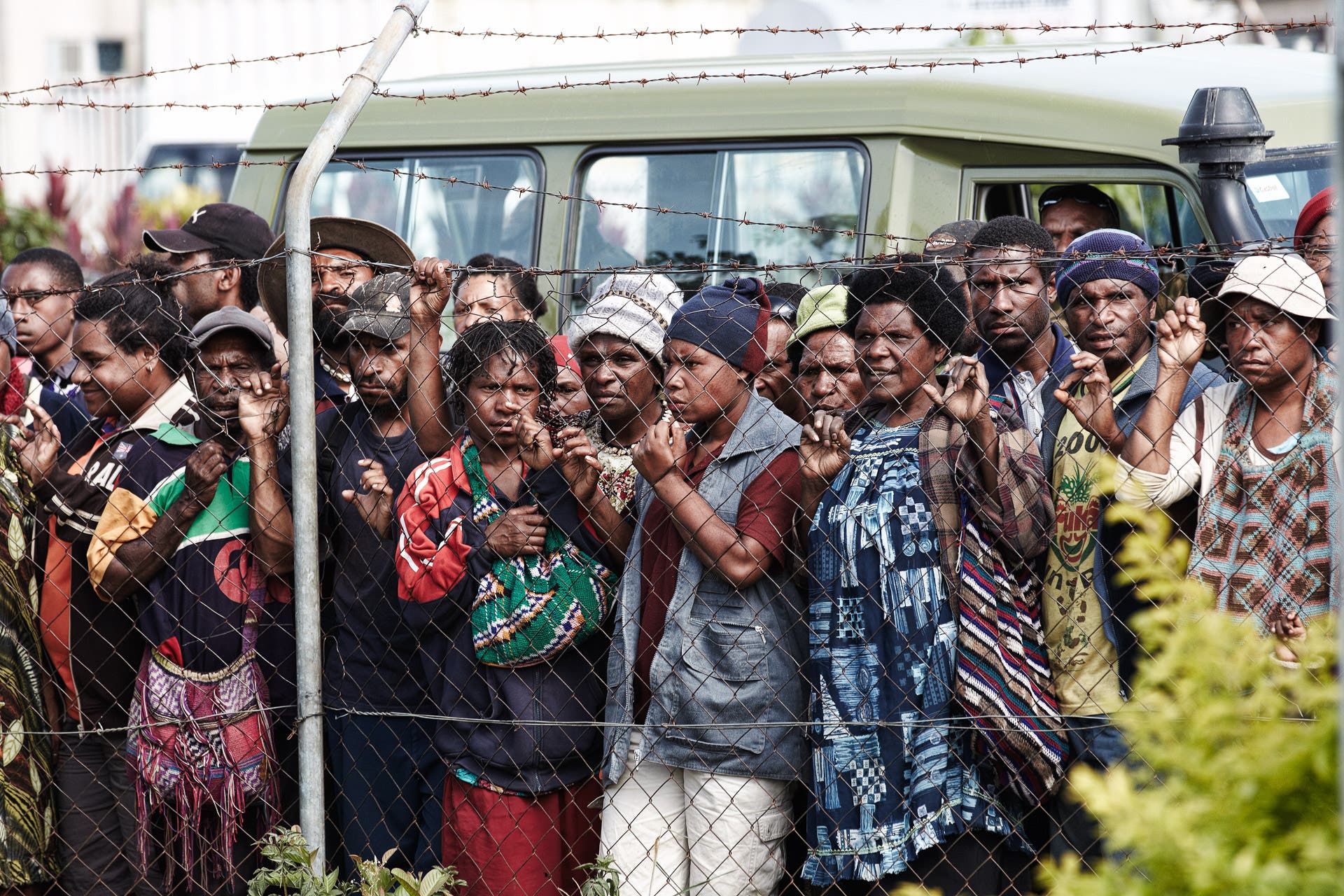 People waiting at the airport fences, urban Mount Hagen, Papua New Guinea.