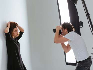 photographer shooting portrait of model in studio