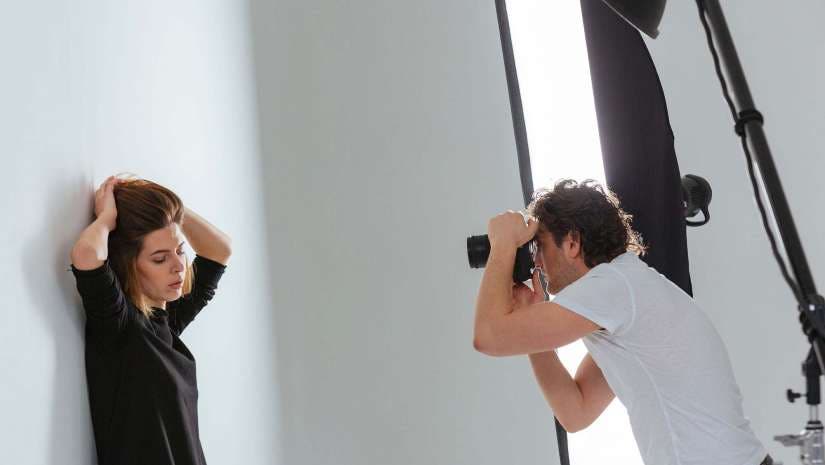 photographer shooting portrait of model in studio