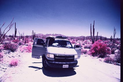 parking car along cactuses infrared photography