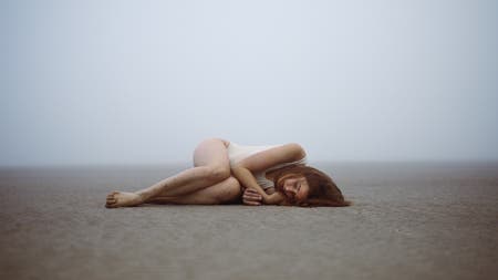 model lying on beach sand