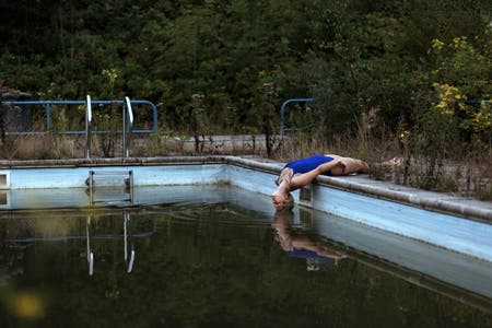 model posing by dirty swimming pool