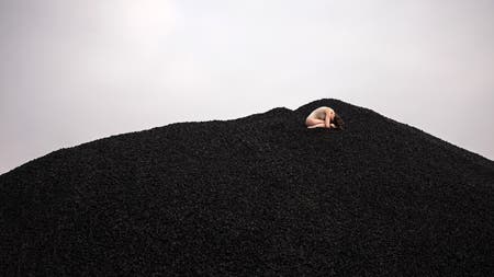 dirty model on a mound of coal