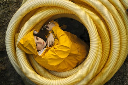 model wearing yellow raincoat inside yellow tubes