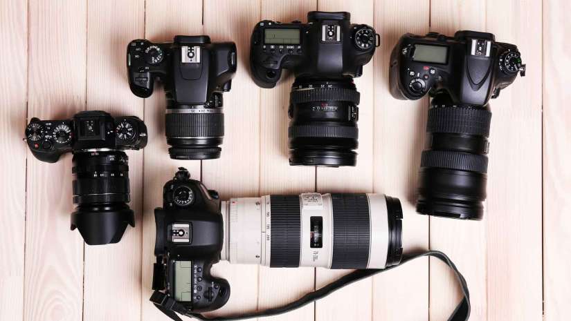 Cameras and Lenses on Wooden Surface