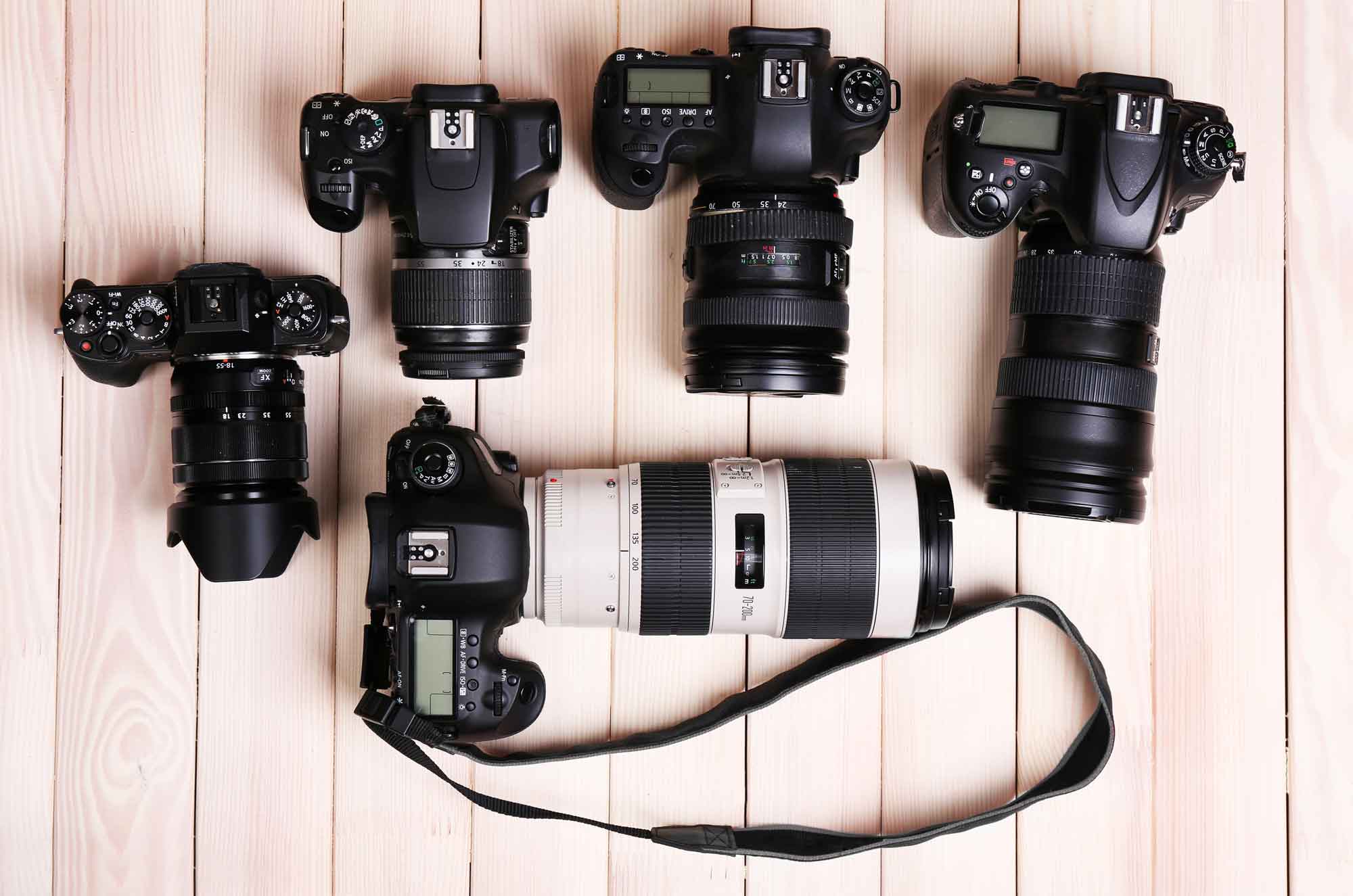 Cameras and Lenses on Wooden Surface
