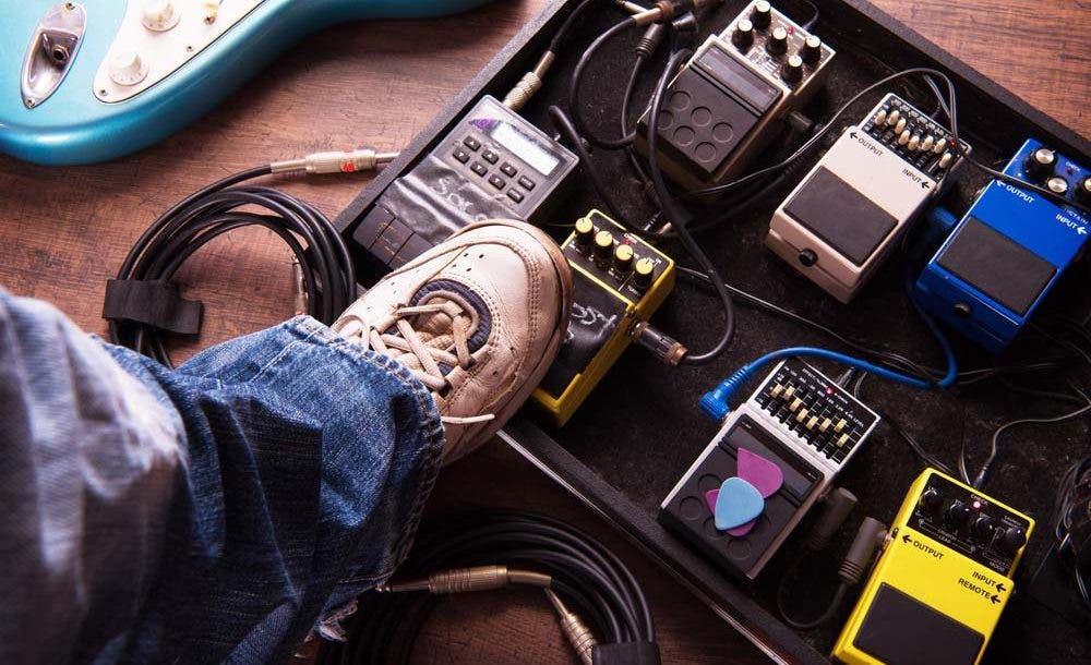 Guitarist Using Guitar Effects Pedals on Pedalboard