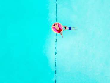 two men relaxing on donut pool floatie drone photography
