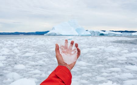hand holding ice in the arctic travel photography