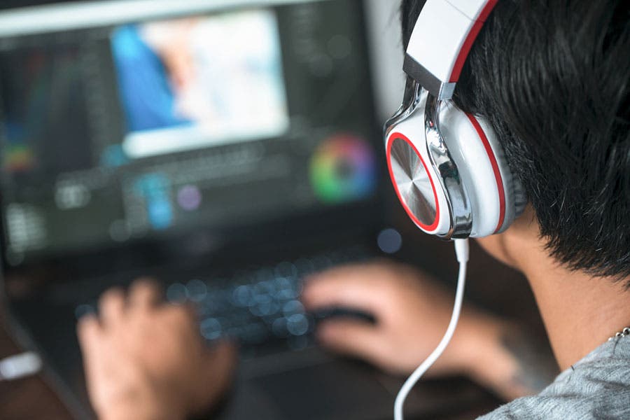 man wearing headphones editing a music video