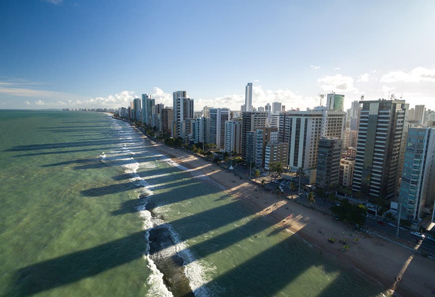 Drone picture of buildings casting long shadows on the beach