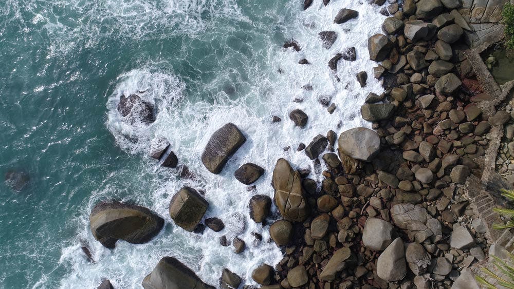 Drone picture of strong waves hitting the rocks on the beach at Phuket, Thailand