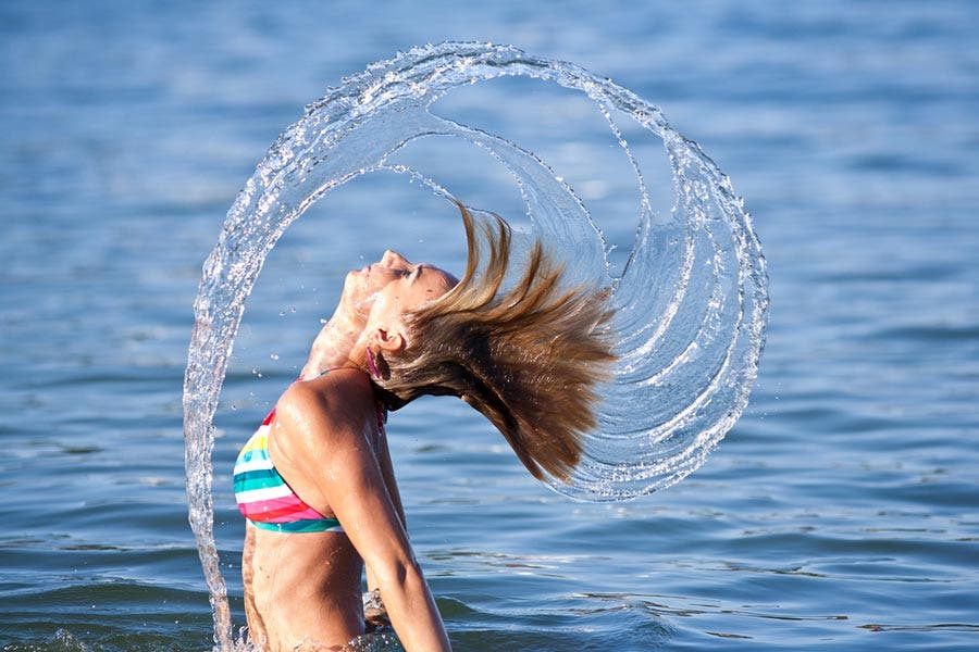 Woman splashing sea water with hair
