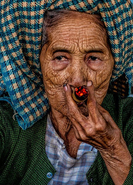 old woman smoking cigar in burma