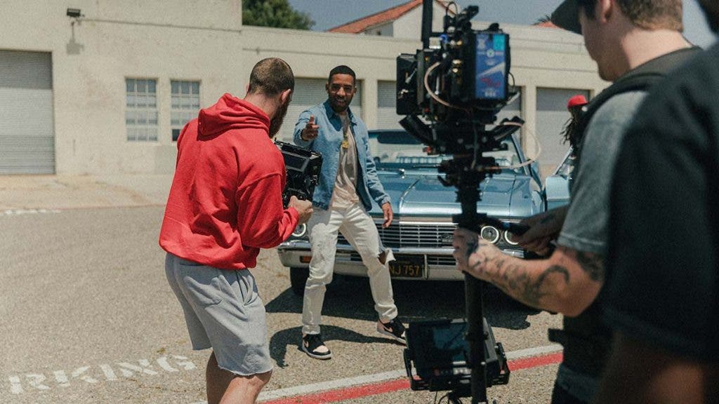 music video equipment on set with performer and car