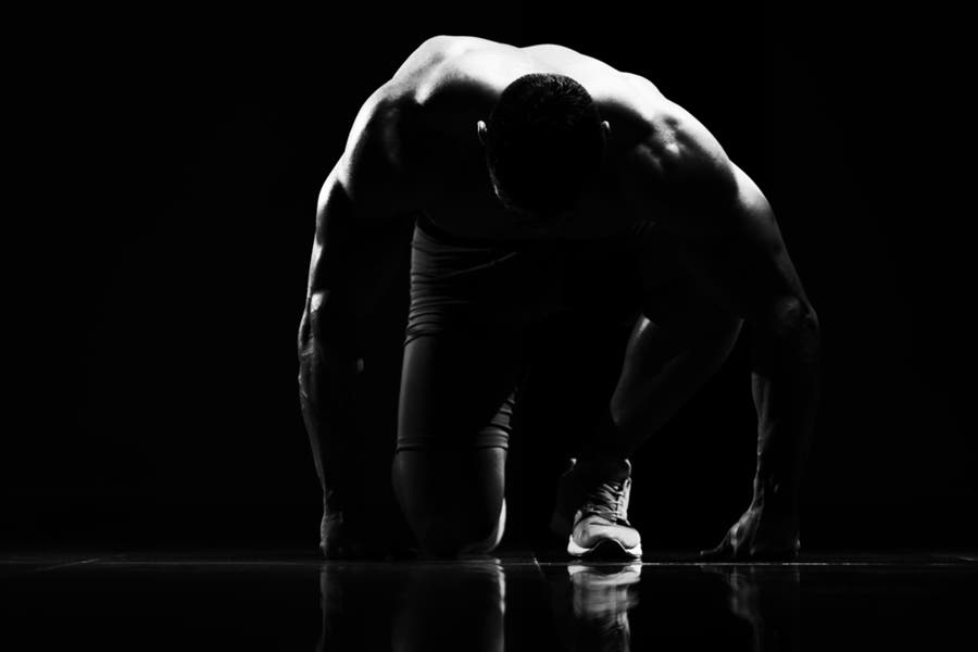 Black and white faceless portrait of muscular man kneeling