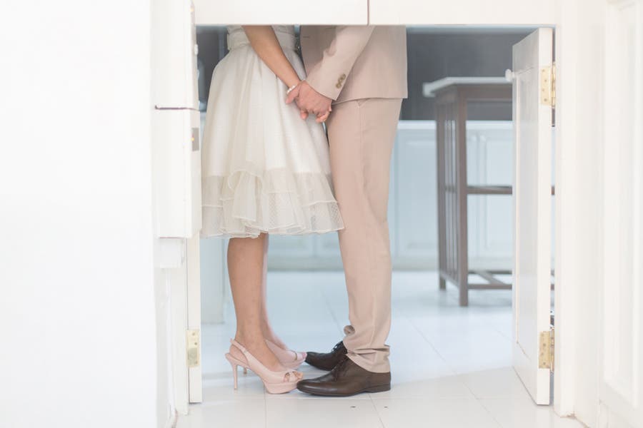Faceless portrait of couple holding hands while facing each other