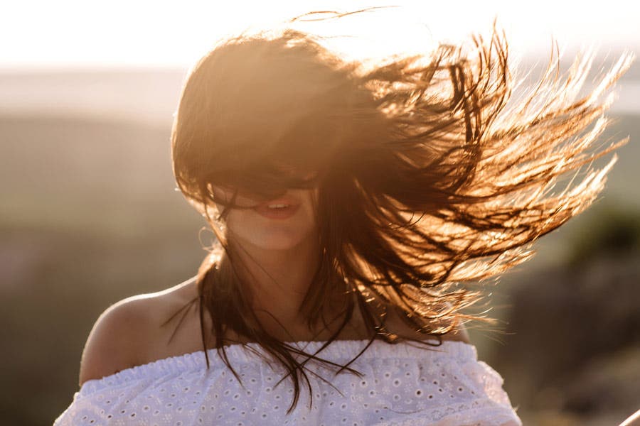 Faceless portrait of woman with hair blowing in the wind