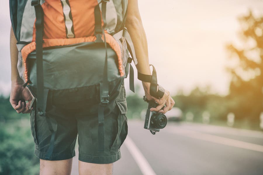 Backpacker holding a mirrorless camera