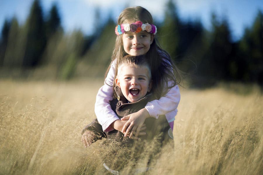 emotional pictures brother and sister hugging in a field portrait photography
