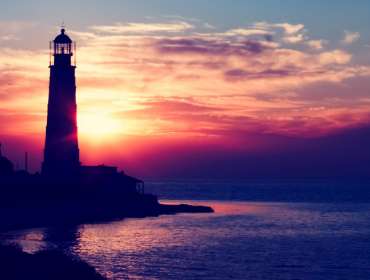 lighthouse by the sea during sunset