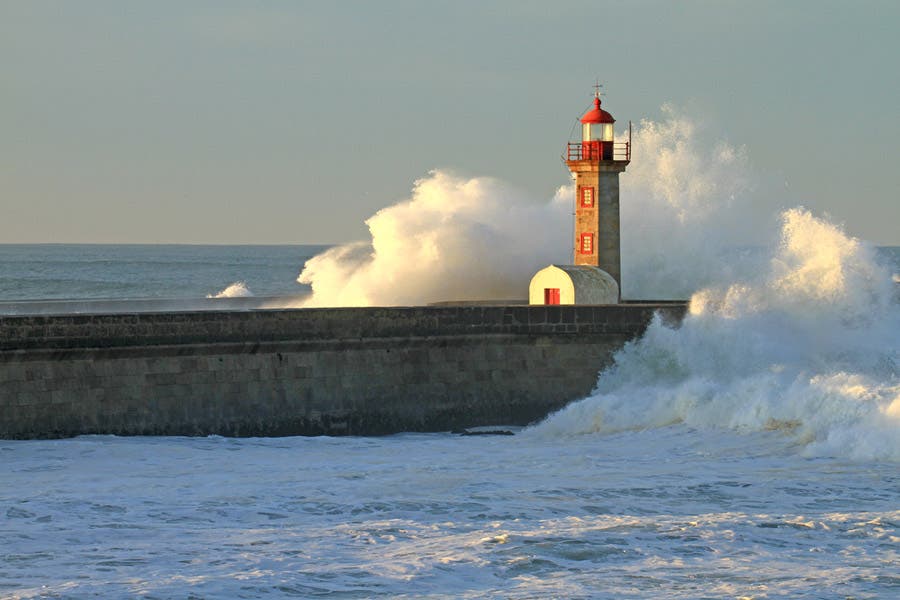 waves crashing violently onto the lighthouse port