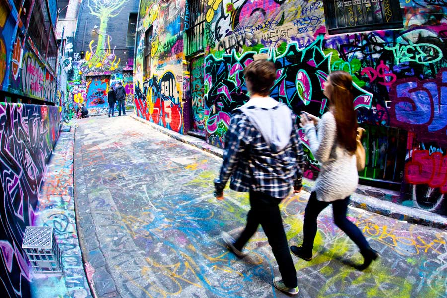 couple walking along street with graffiti art in Melbourne, Australia
