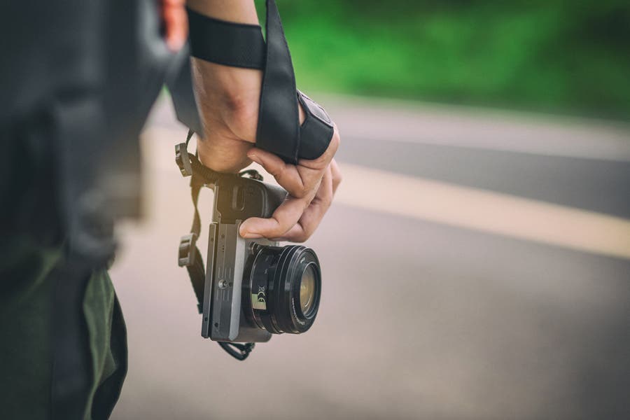 man holding a mirrorless camera for street photography