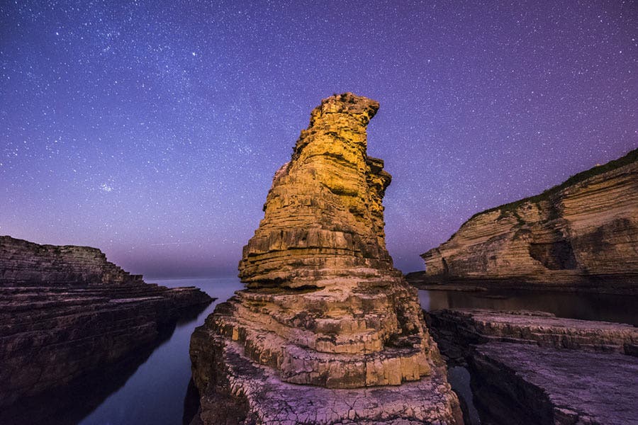 rock formation with purple sky astrophotography night photography