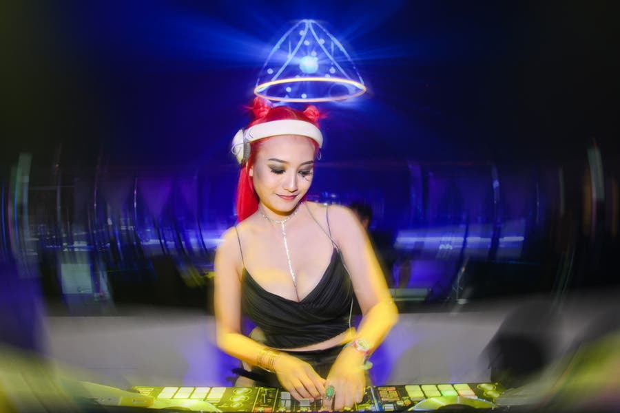 Photo of female dj in club using slow sync flash
