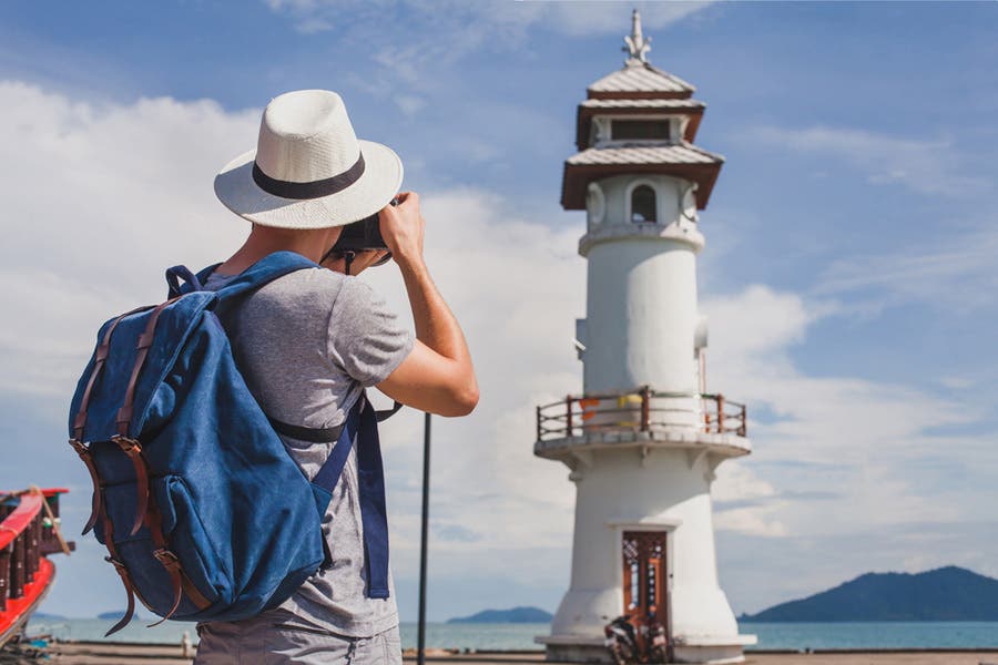 woman taking photo of lighthouse