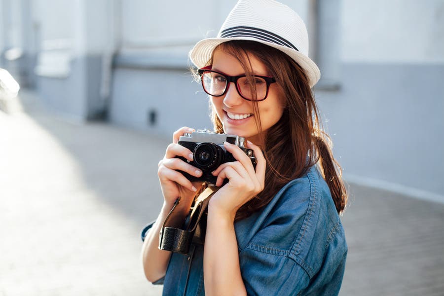 Woman posing with camera in hand