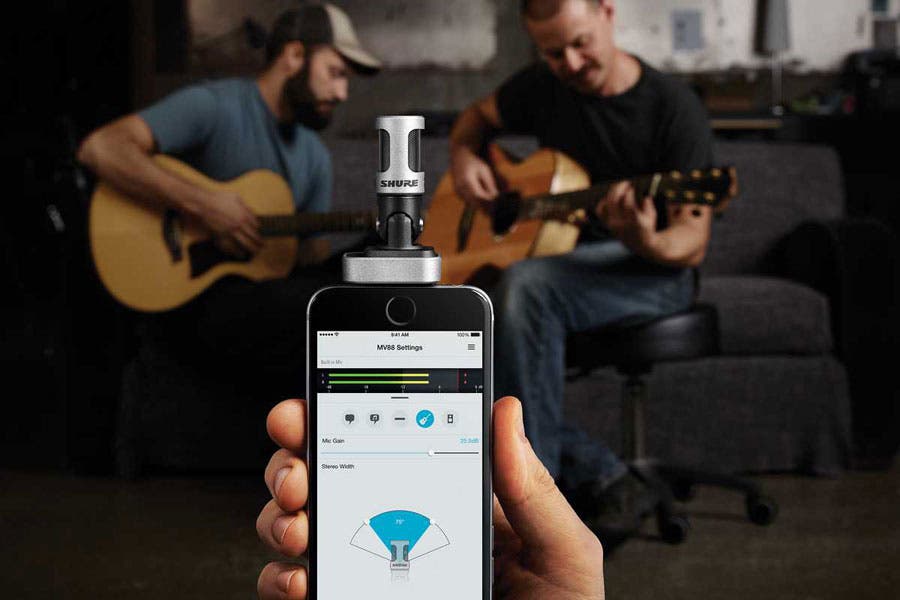 two musicians being recorded with a Shure microphone