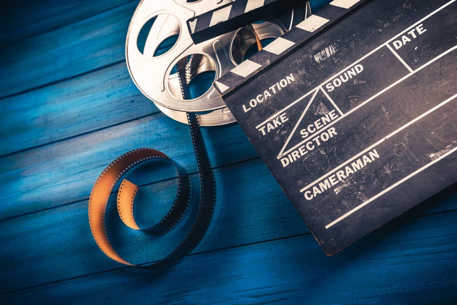 Film roll and clapper on wooden blue surface
