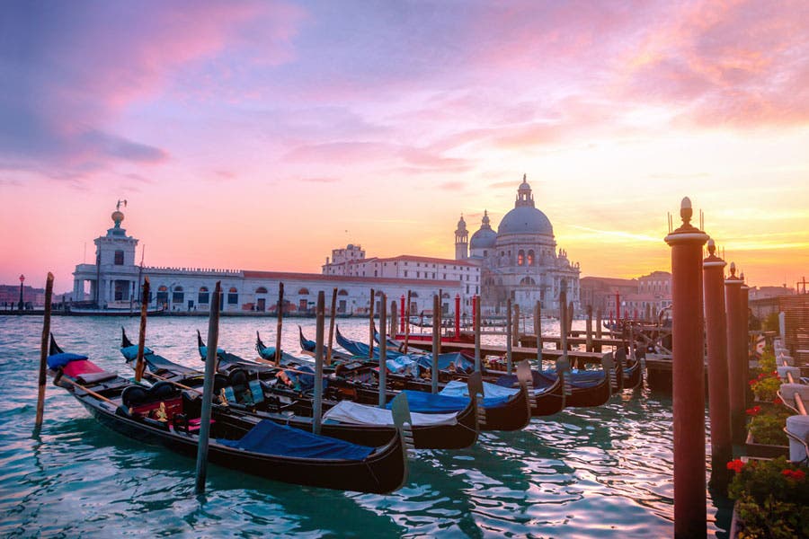 Colorful photo of gondolas at sunset in Venice