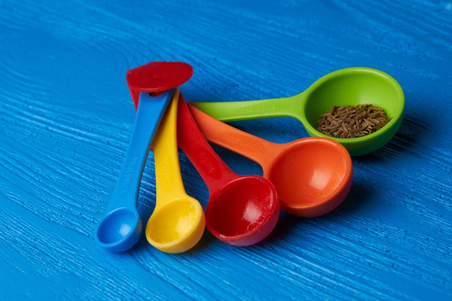 Colorful measuring spoons on a blue table