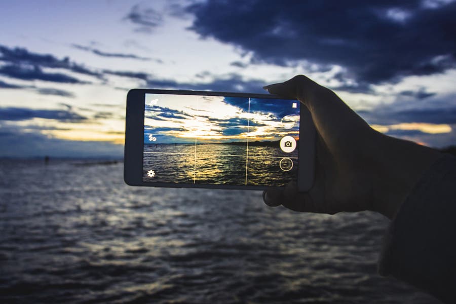 person composing a photo outdoors