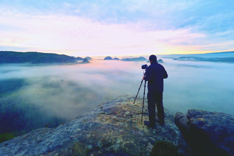 Photographer shooting landscape from mountain top
