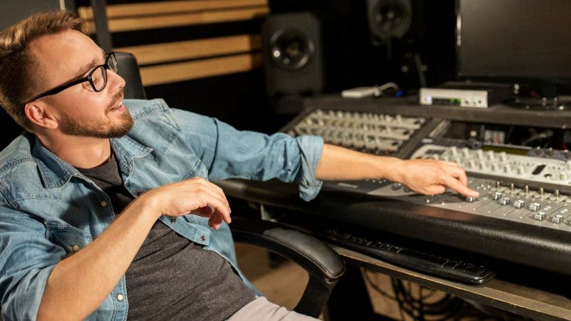 Music producer behind recording studio booth