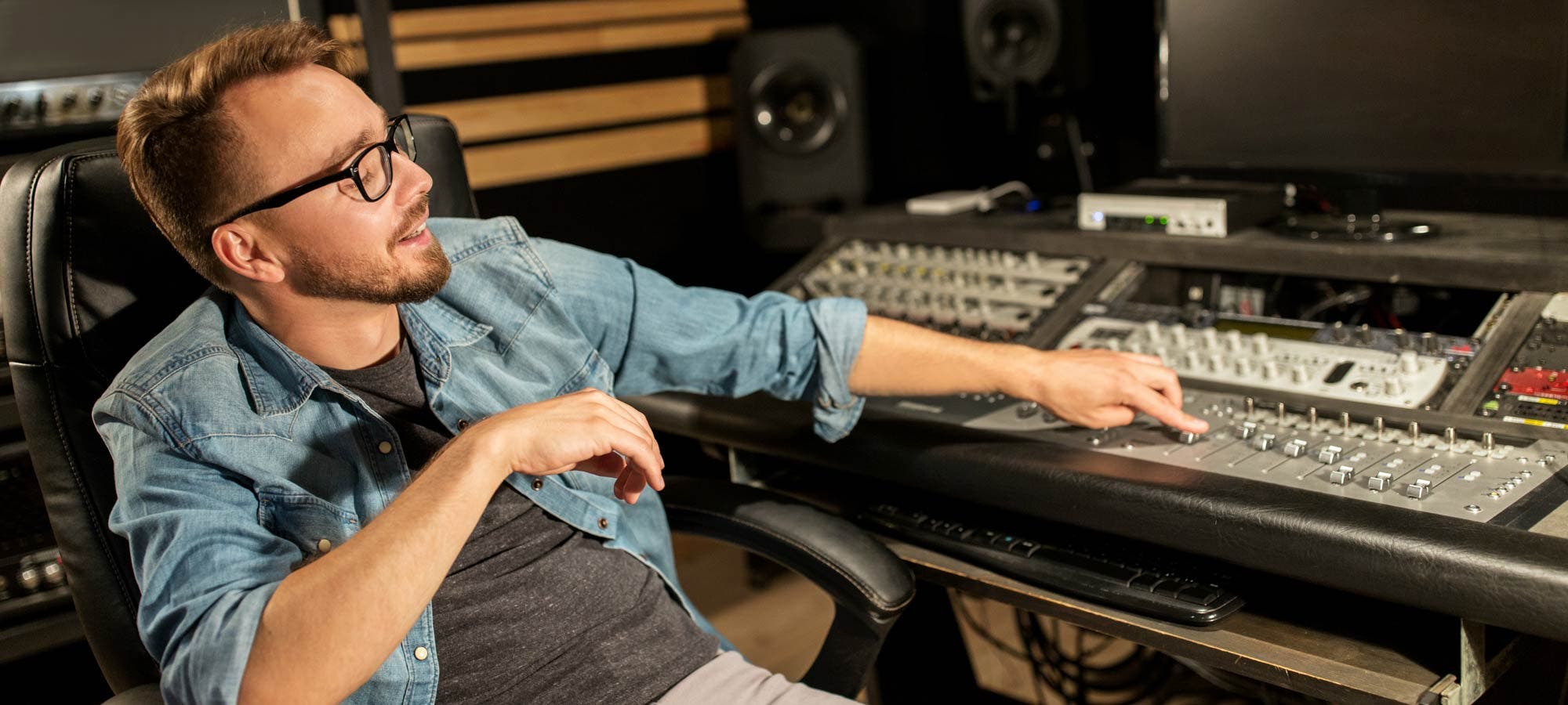 Music producer behind recording studio booth