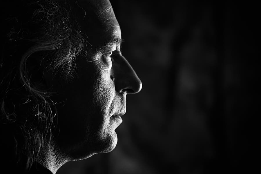 Low key closeup side portrait of man with side lighting