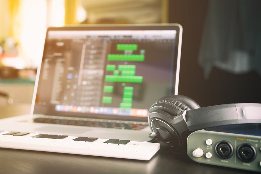 laptop with MIDI, headphones, and audio interface for music production