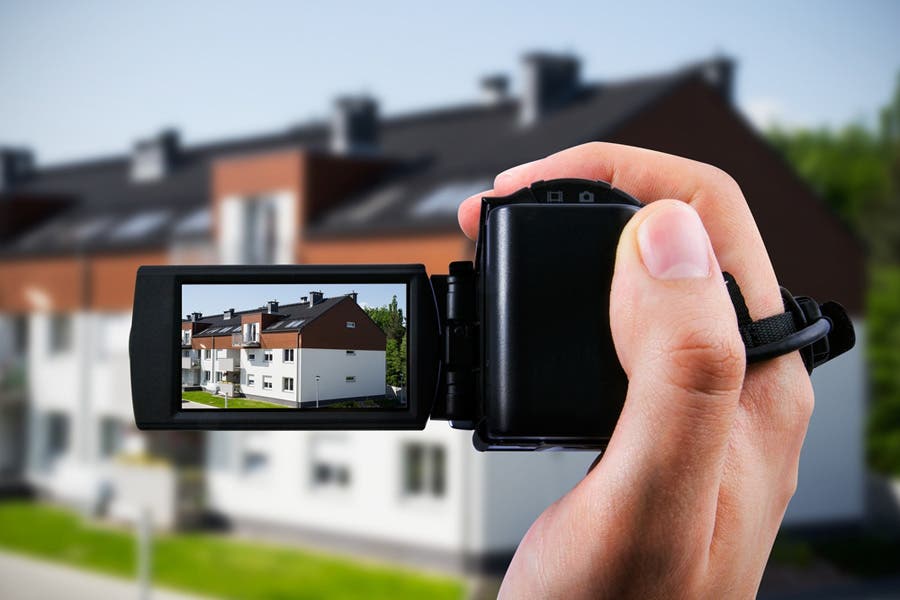 A camcorder capturing footage of a house