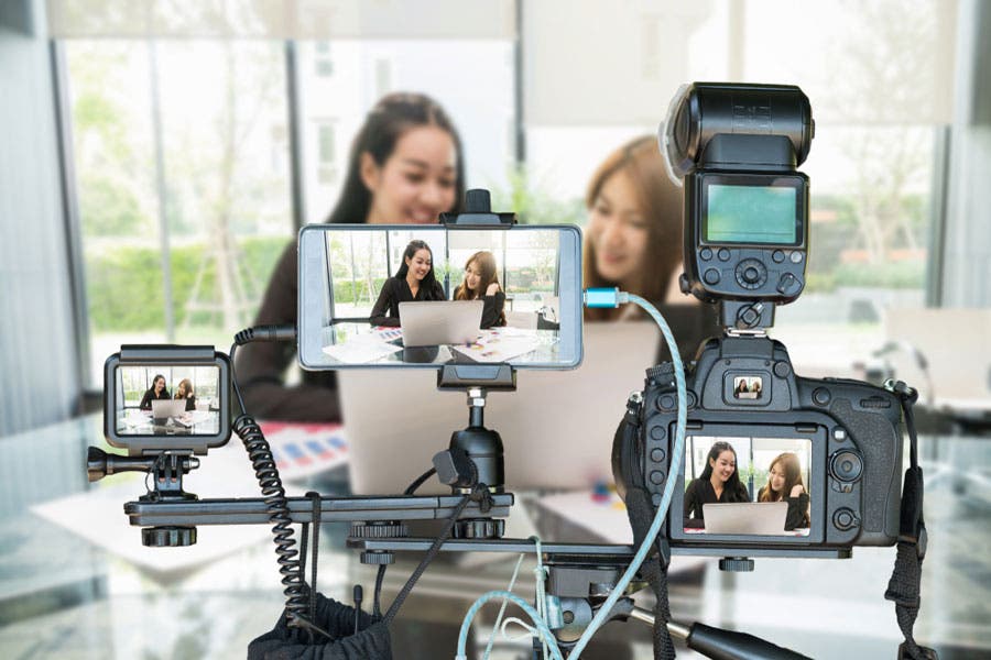 Two Asian girls making YouTube videos using three different types of cameras