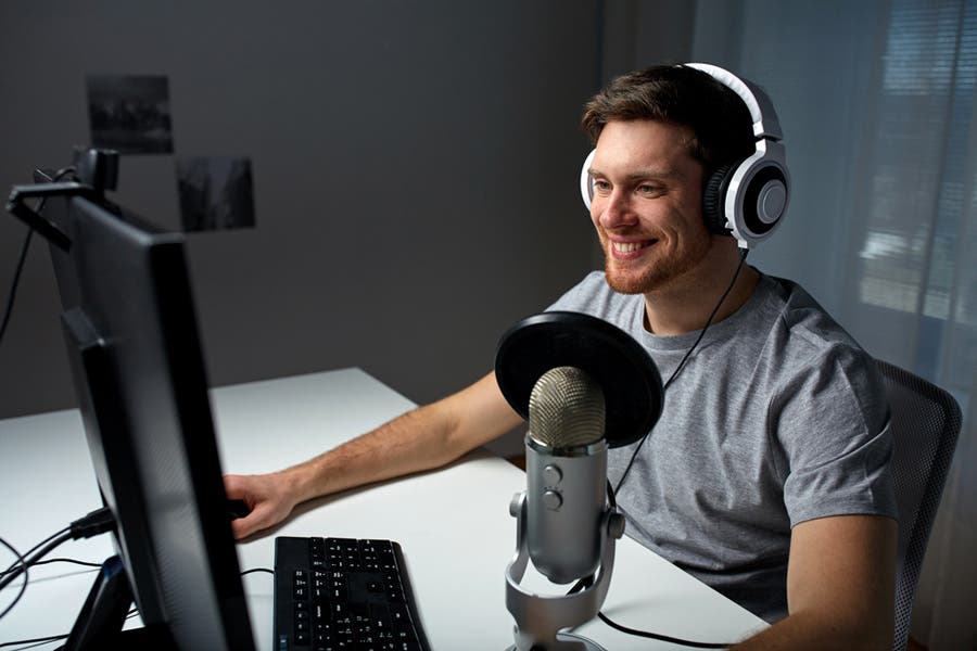 Computer gamer using PC, headphones, and studio microphone