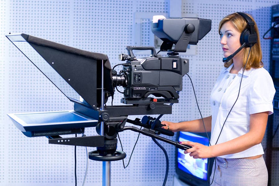 Camerawoman operates video camera and teleprompter
