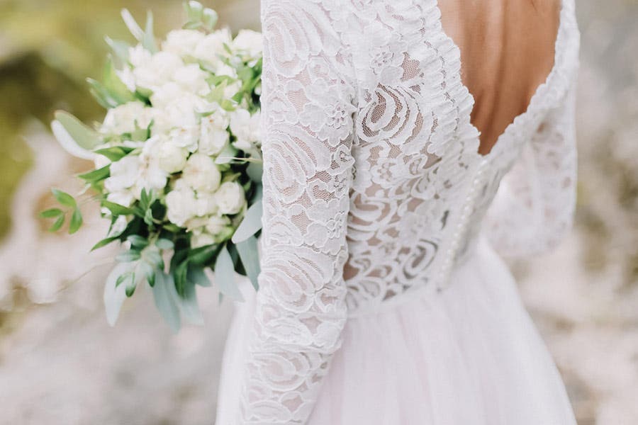 Fine art wedding photo showing bridal gown details and bouquet