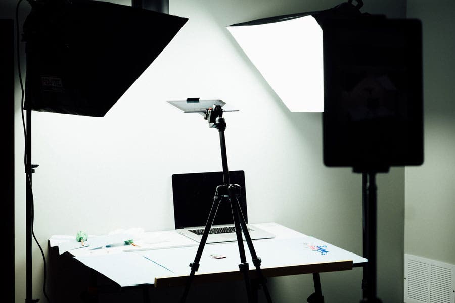 softbox lights illuminate a desk with a laptop and smartphone mounted on a tripod